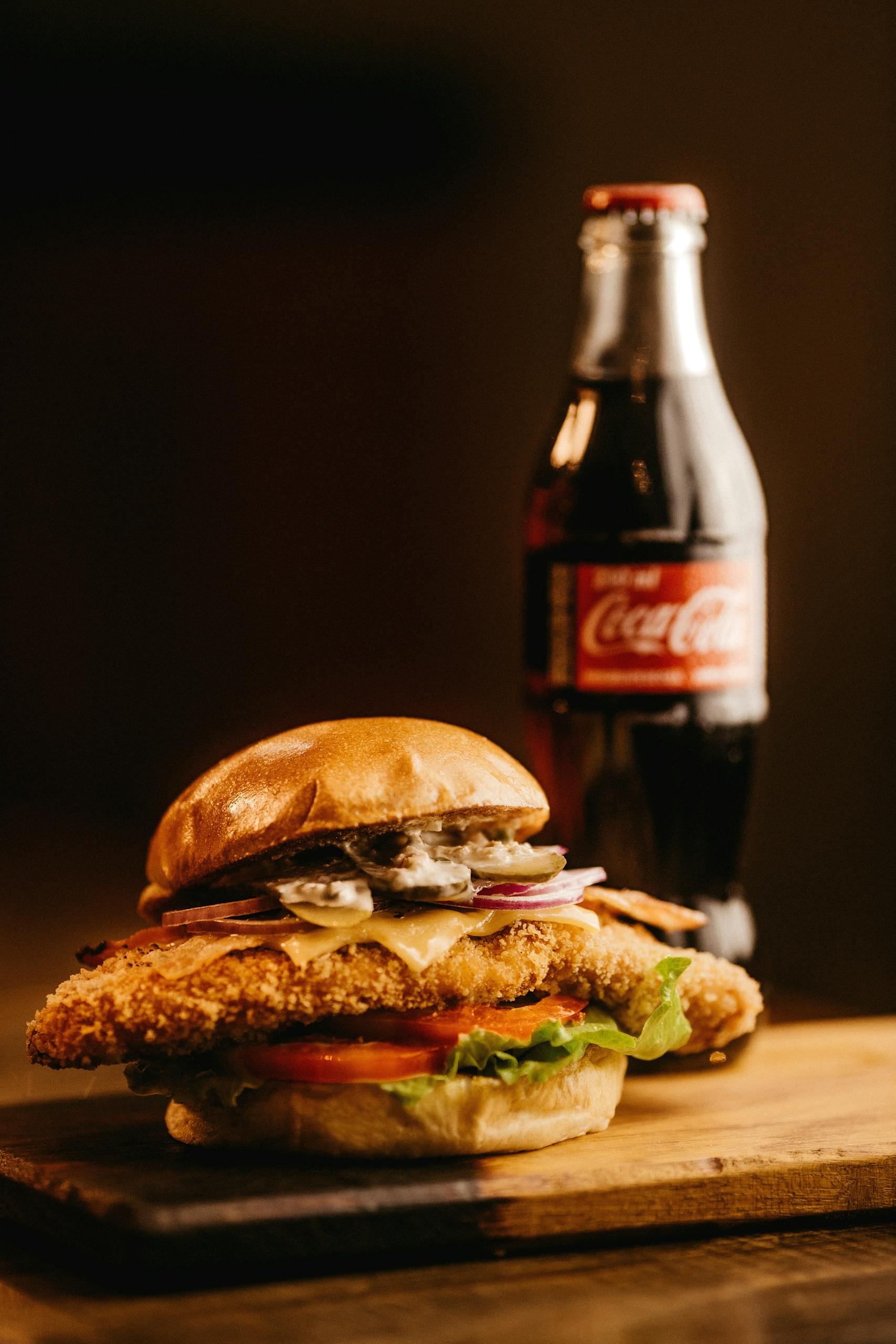 Mouth-watering burger with a bottle of cola, perfect for fast food lovers.
